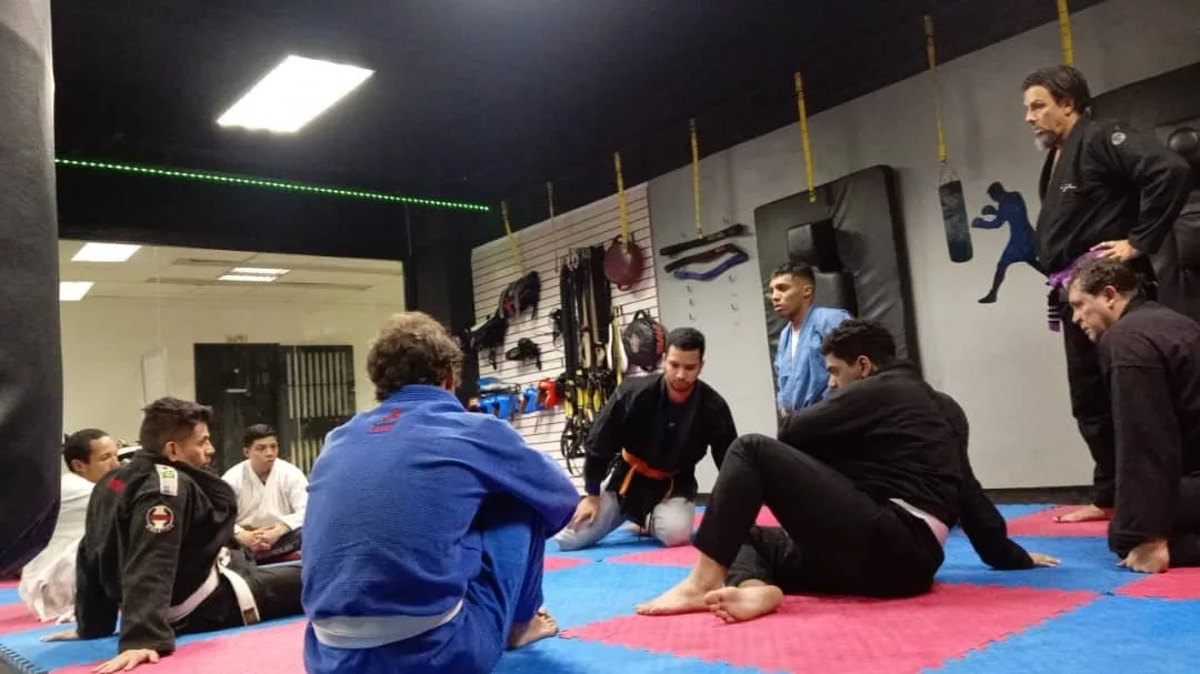 Rodrigo explicando una técnica a los alumnos sentados en el tatami
